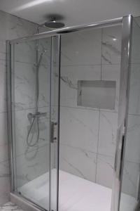 a shower with a glass door in a bathroom at 5 star Apartment in London