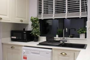 a kitchen with a sink and a microwave at 5 star Apartment in London