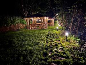 a gazebo with lights in a yard at night at Willa FOLK Pieniny in Szczawnica
