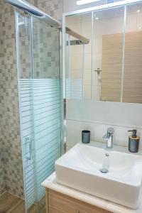 uma casa de banho com um lavatório e uma cabina de duche em vidro. em Doris home in Ilha de Rhodes