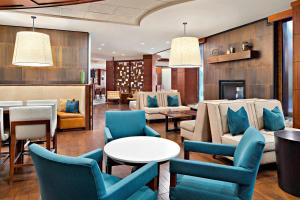 a hotel lobby with blue chairs and a table at Fort Collins Marriott in Fort Collins