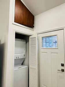 una cocina con lavadora y secadora y una puerta en Fab lil home Central to all NOLA / near City Park en Nueva Orleans
