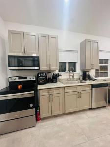 a kitchen with white cabinets and a black stove top oven at Fab lil home Central to all NOLA / near City Park in New Orleans