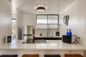 cocina con encimera y nevera en Maunaloa Shores 109, en Hilo