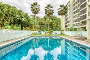 una piscina en un hotel con palmeras en Maunaloa Shores 109, en Hilo