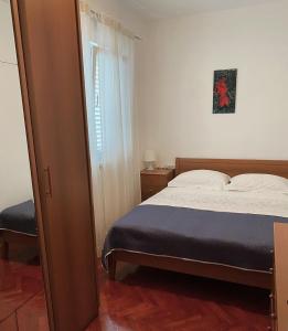 a small bedroom with a bed and a window at Apartment Elanda Downtown in Zadar