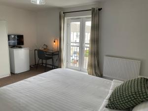 1 dormitorio con cama, escritorio y ventana en Luxury Rooms In Furnished Guests-Only House Free WiFi West Thurrock, en Grays