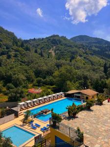 a resort with a swimming pool and mountains in the background at Apart Hotel Blumarin in Agios Gordios