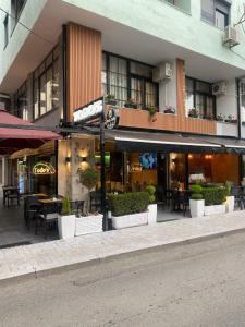 budynek ze stołami i krzesłami na ulicy w obiekcie Todo apartements w Durrës
