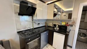 eine Küche mit weißen Schränken und einer schwarzen Arbeitsplatte in der Unterkunft Mar Boutique Apartment in Istanbul
