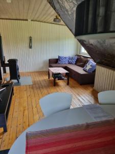 uma sala de estar com um sofá e uma mesa em Lägenhet på hästgård em Ljungbyhed