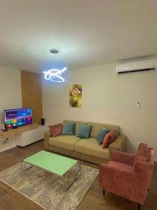 sala de estar con sofá y TV en Like my home apartment, en Durrës