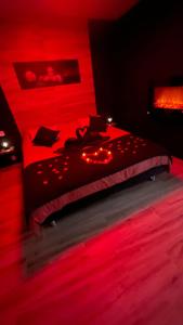 Un dormitorio con una cama con luces rojas. en Loft sauna jacuzzi ospariegeois, en Lavelanet