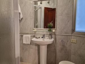 W łazience znajduje się umywalka i lustro. w obiekcie Apartamento Raxobrisamar w mieście Raxo