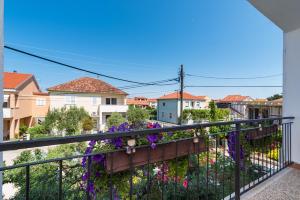 - un balcon orné de fleurs violettes sur une clôture dans l'établissement Apartment MAVI, à Zadar