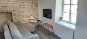 een woonkamer met een bank en een tv bij Maison de 2 chambres avec wifi a Quimperle in Quimperlé