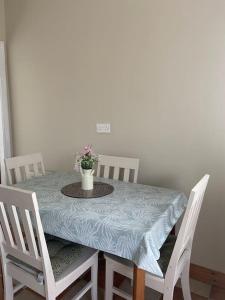 a dining room table with a vase of flowers on it at Shannon Breeze lodge in Kilrush