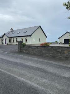 a white house with a fence and a street at Shannon Breeze lodge in Kilrush