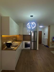 cocina con nevera de acero inoxidable y lámpara de araña en Like my home apartment, en Durrës