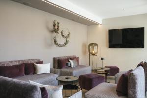 Il comprend un salon avec des canapés et une télévision à écran plat. dans l'établissement Residence Sonja - Apartment Picea, à Rablà