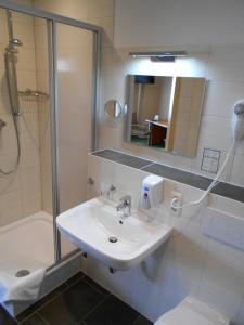 a bathroom with a sink and a shower and a toilet at Síu Hotel Magdeburg in Magdeburg