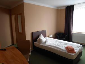 um quarto de hotel com uma cama, uma mesa e uma janela em Síu Hotel Magdeburg em Magdeburg