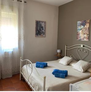Un dormitorio con una cama con almohadas azules. en Cas'Ilenia Lido Azzurro, en Porto Empedocle