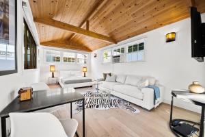 una sala de estar con muebles blancos y techo de madera. en Prestige Studio City Estate en Los Ángeles