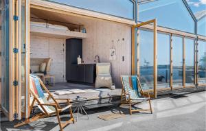 um quarto com duas cadeiras, uma cama e janelas em Gorgeous Apartment In Aarhus C With Harbor View em Aarhus