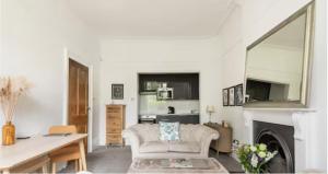 a living room with a couch and a mirror at Spacious 1 bed in Primrose Hill in London