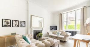 a living room with two couches and a fireplace at Spacious 1 bed in Primrose Hill in London