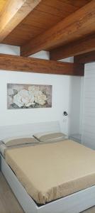 1 cama en un dormitorio con una pintura en la pared en MIRTO di Sardegna, en Assemini
