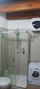 y baño con ducha, lavabo y lavadora. en MIRTO di Sardegna, en Assemini