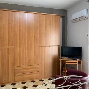 un gran armario de madera en una habitación con TV en Cas'Ilenia Lido Azzurro en Porto Empedocle
