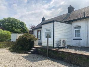 une petite maison blanche avec une fenêtre et anxieuses dans l'établissement Old Station House - Kilfillan Cottage, à Garlieston
