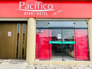a store with a red sign on the front of a building at Apart-Hotel Pacífico in Tramandaí