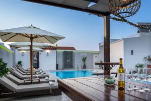 a patio with a pool and a table with wine glasses at Pervolia House in Kremasti