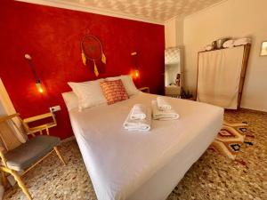 une chambre avec un grand lit blanc avec un mur rouge dans l'établissement Mountain Retreat with stunning terrace views, à Pedralba