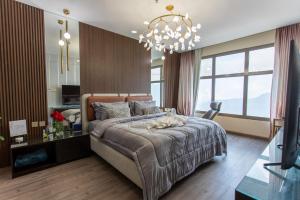 Un dormitorio con una cama grande y una lámpara de araña. en فلل المدينة العالية الجديدة High City Villa VIP, en Abha