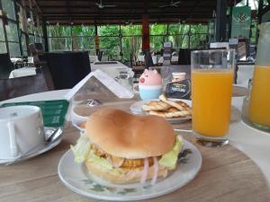a sandwich on a plate on a table with two glasses of orange juice at Amazon Lodge Varillal in Iquitos