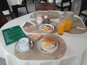a table with a plate of breakfast food and orange juice at Amazon Lodge Varillal in Iquitos