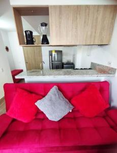 a red couch with red pillows in a kitchen at Espectacular Aparta Estudio Armenia Quindío in Armenia +2 photos