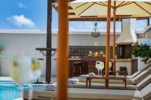 a wine glass sitting on a table with an umbrella at Pervolia House in Kremasti