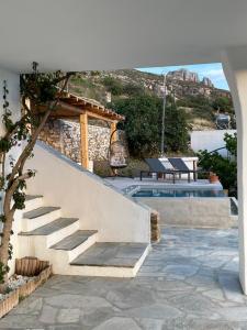 a staircase next to a swimming pool with a table at Euphoria Tinos Suite in Skaládhos