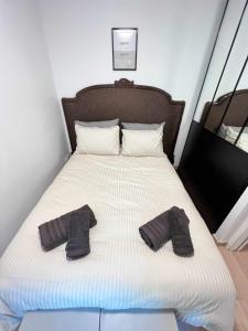 a bed with two pairs of black socks on it at Very quiet apartment with balcony in Saint-Denis