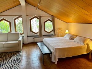 ein Schlafzimmer mit einem Bett und einer Couch und Fenstern in der Unterkunft MAD di Mare di Arte Dormire in Celle Ligure