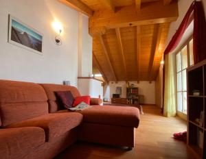un soggiorno con divano marrone e soffitti in legno di Villetta Thun a Ton