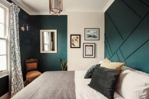 a bedroom with a large bed and a green wall at Artistic hideaway within York’s ancient city walls in York