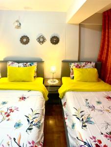 2 camas en una habitación con sábanas blancas y amarillas en Cusco Mágico 1 - Aparthotel Condominio Las Torres Kayser I, en Cusco