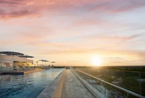 - une vue sur la piscine et le coucher de soleil en arrière-plan dans l'établissement Courtyard by Marriott Merida Downtown, à Mérida